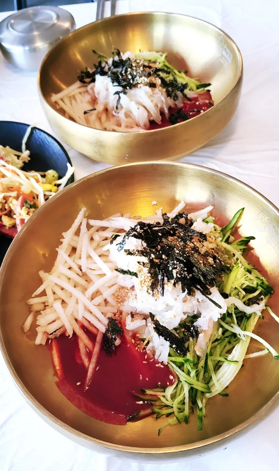 Two bowls of Ppwang Mulhoe's half-and-half mulhoe and flounder mulhoe