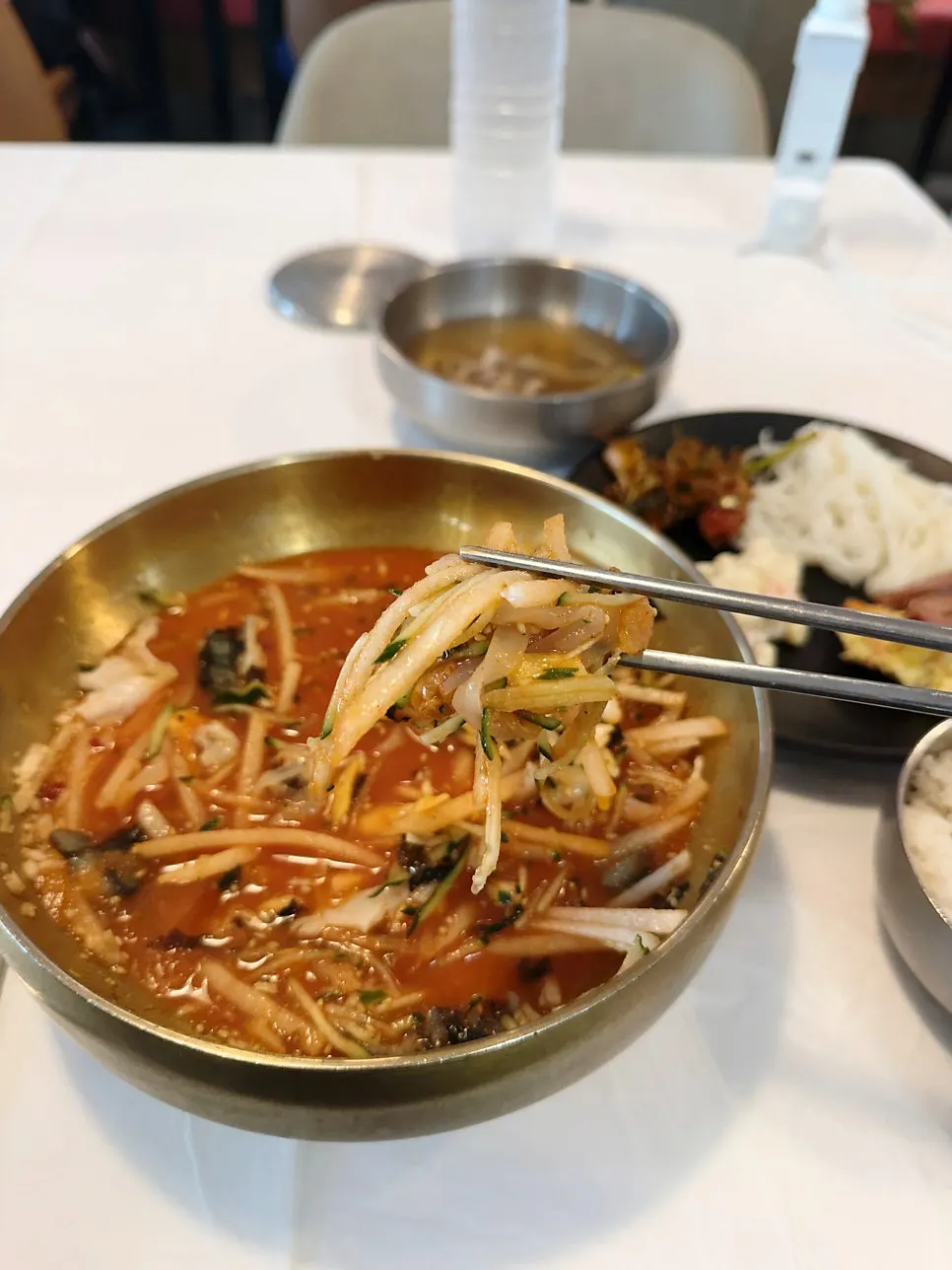 Noodles and cucumber lifted together into mulhoe-guksu