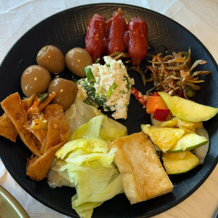 A springy piece of squid sashimi lifted with chopsticks