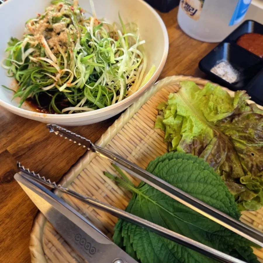A plate of fresh green lettuce wraps and green onion salad