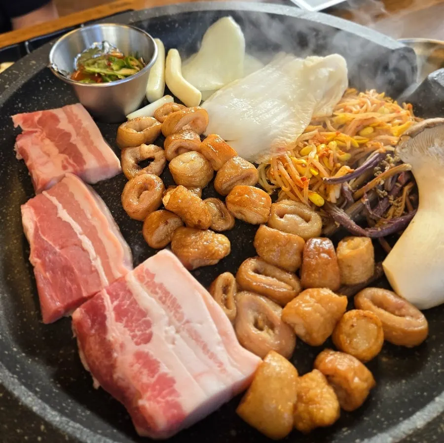 Pre-cooked makchang and aged pork belly on the grill