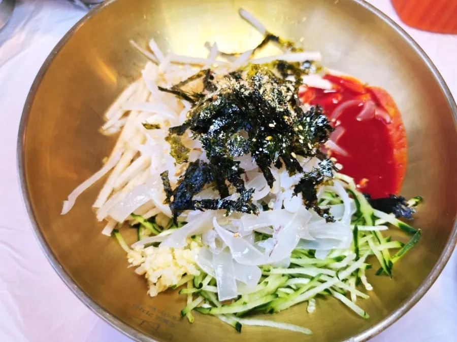 Close-up of Ppwang Mulhoe topped with abalone, sea cucumber, and sea squirt