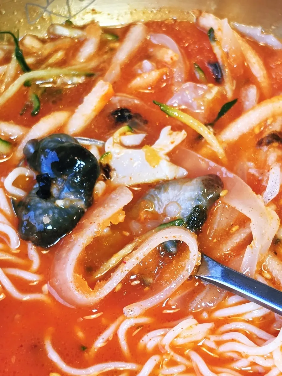 A bite of squid mulhoe mixed into the spicy-sweet broth