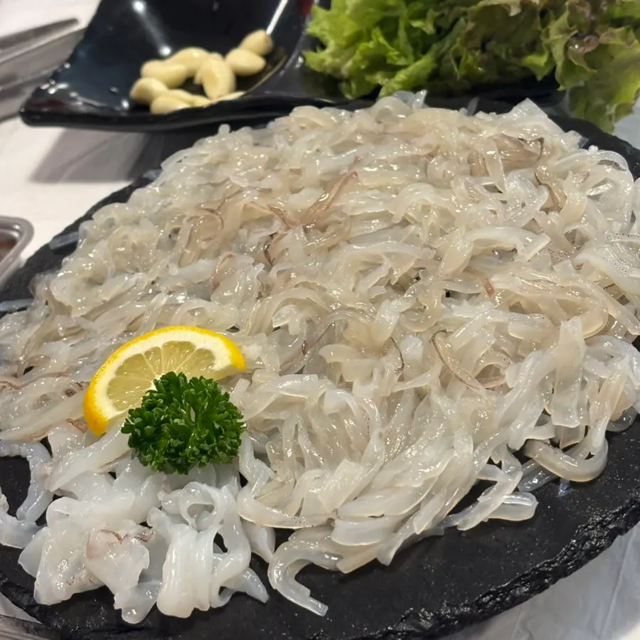 Squid sashimi with a complimentary side of flounder sashimi