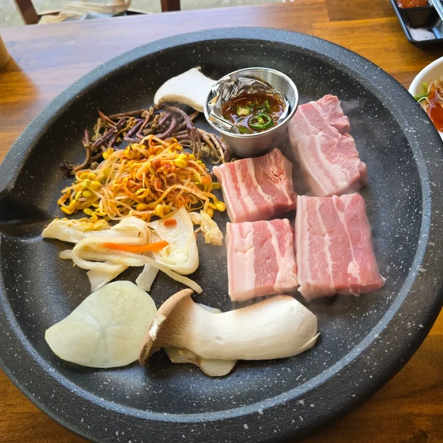 Ogyeopsal cooking on the stone plate
