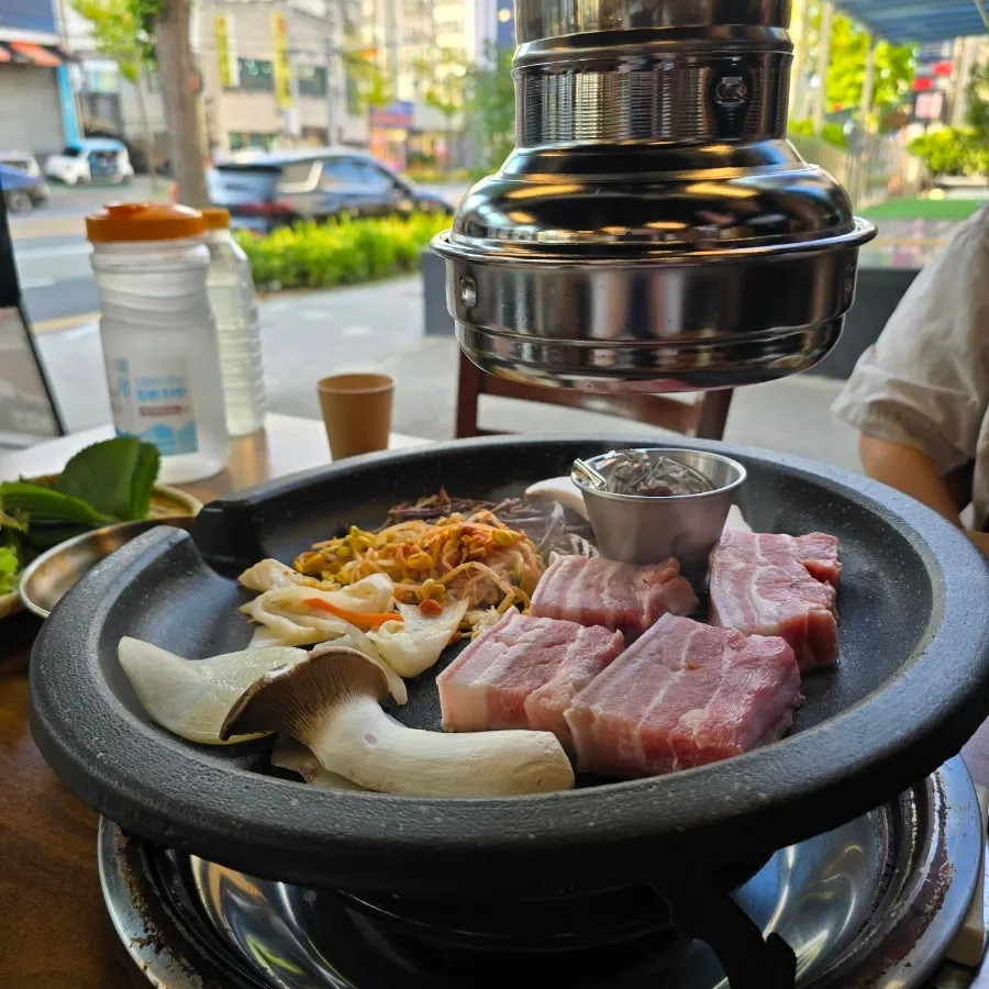 Ogyeopsal grilling alongside vegetables