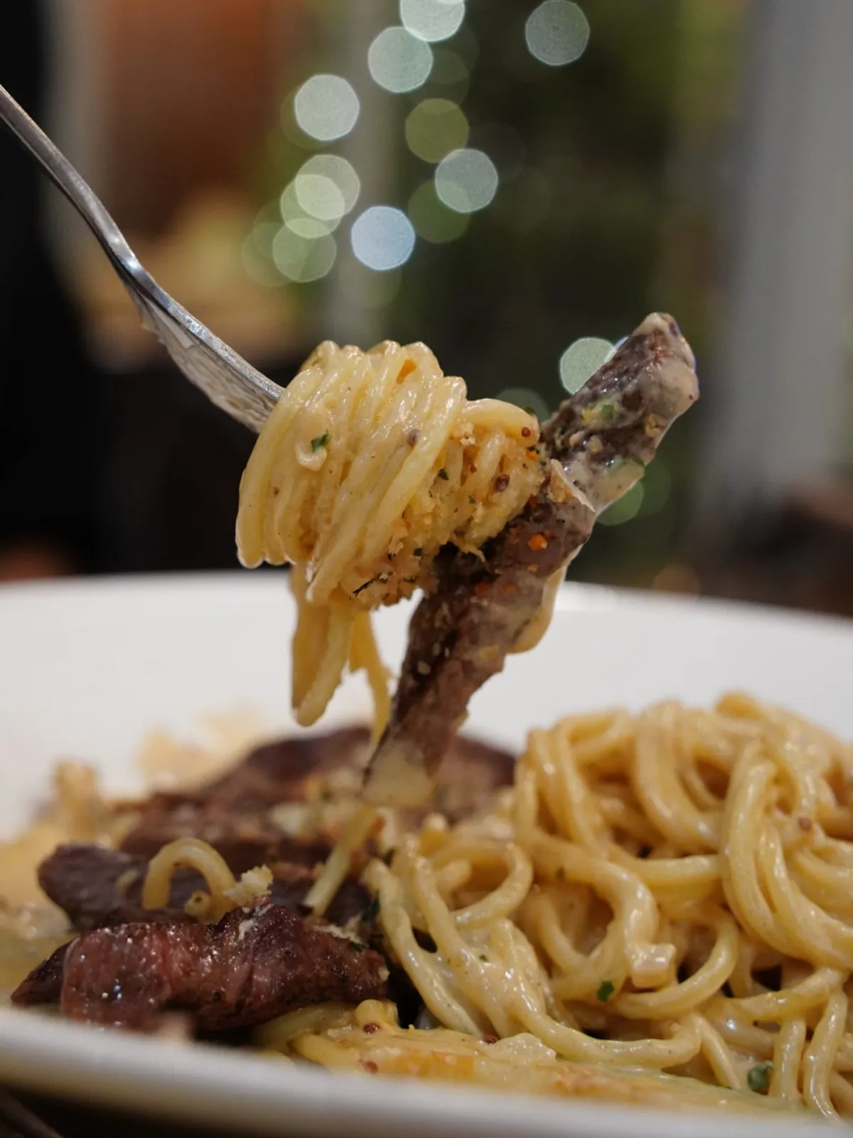 Pasta noodles coated in cream sauce with salchisal