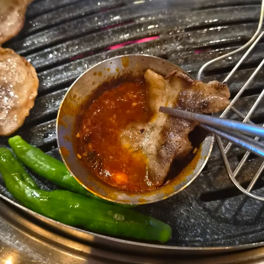 Pork belly served with wild garlic leaves and salted hairtail sauce