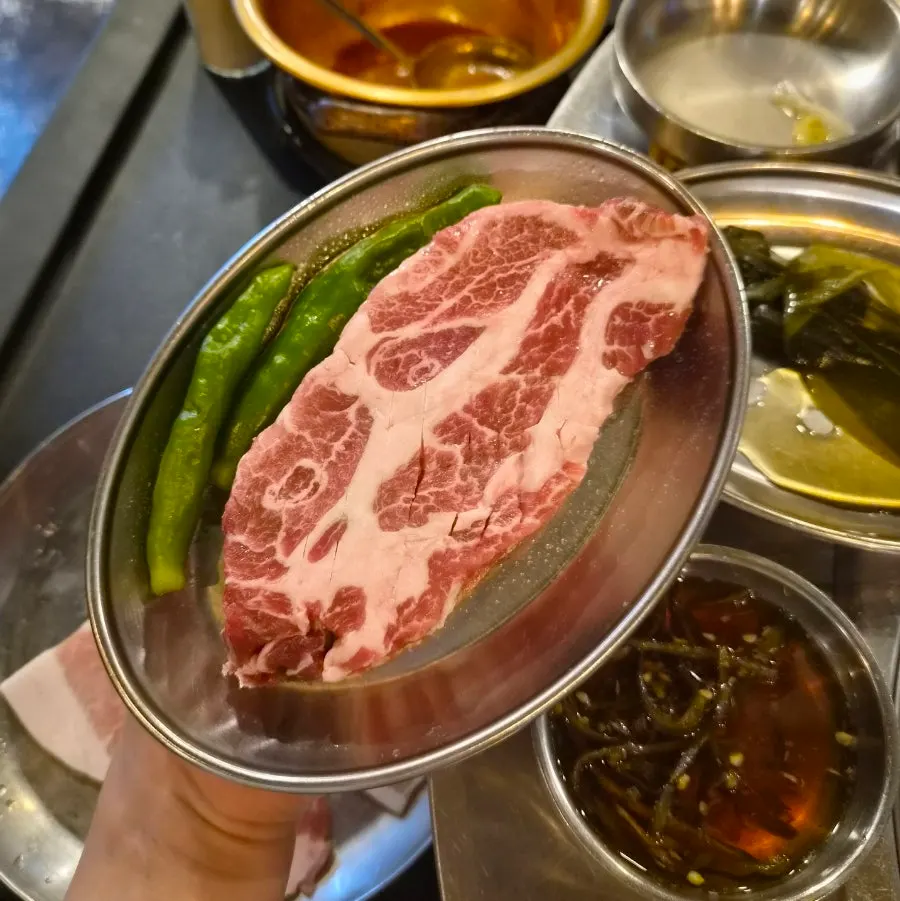 A single portion of thick-cut pork neck set on the table
