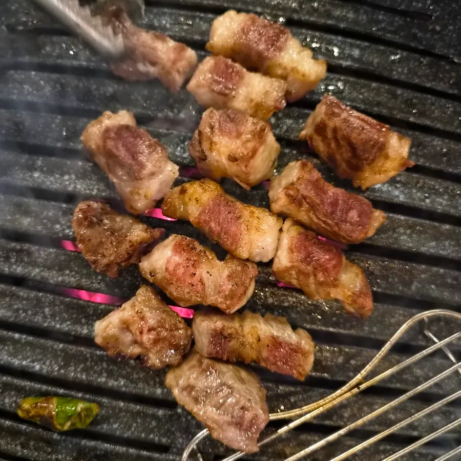 Sliced Iberico pork neck being cooked