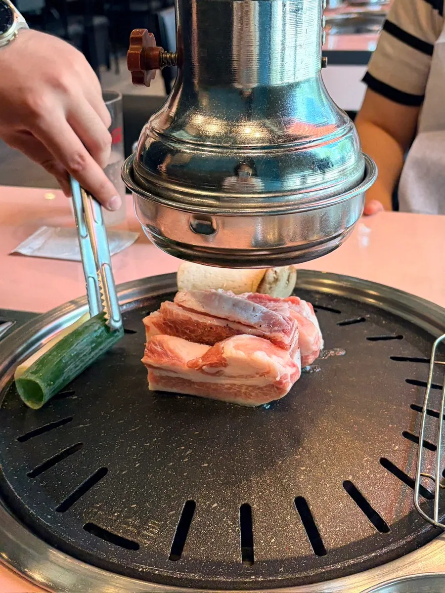 직원이 불판에서 삼겹살을 굽는 모습