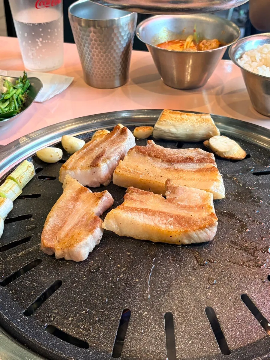 불판 위에서 익어가는 삼겹살과 대파