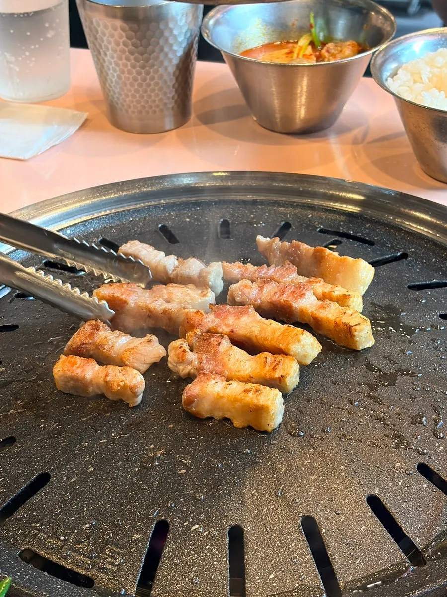 구워지는 삼겹살과 함께 올려진 미나리