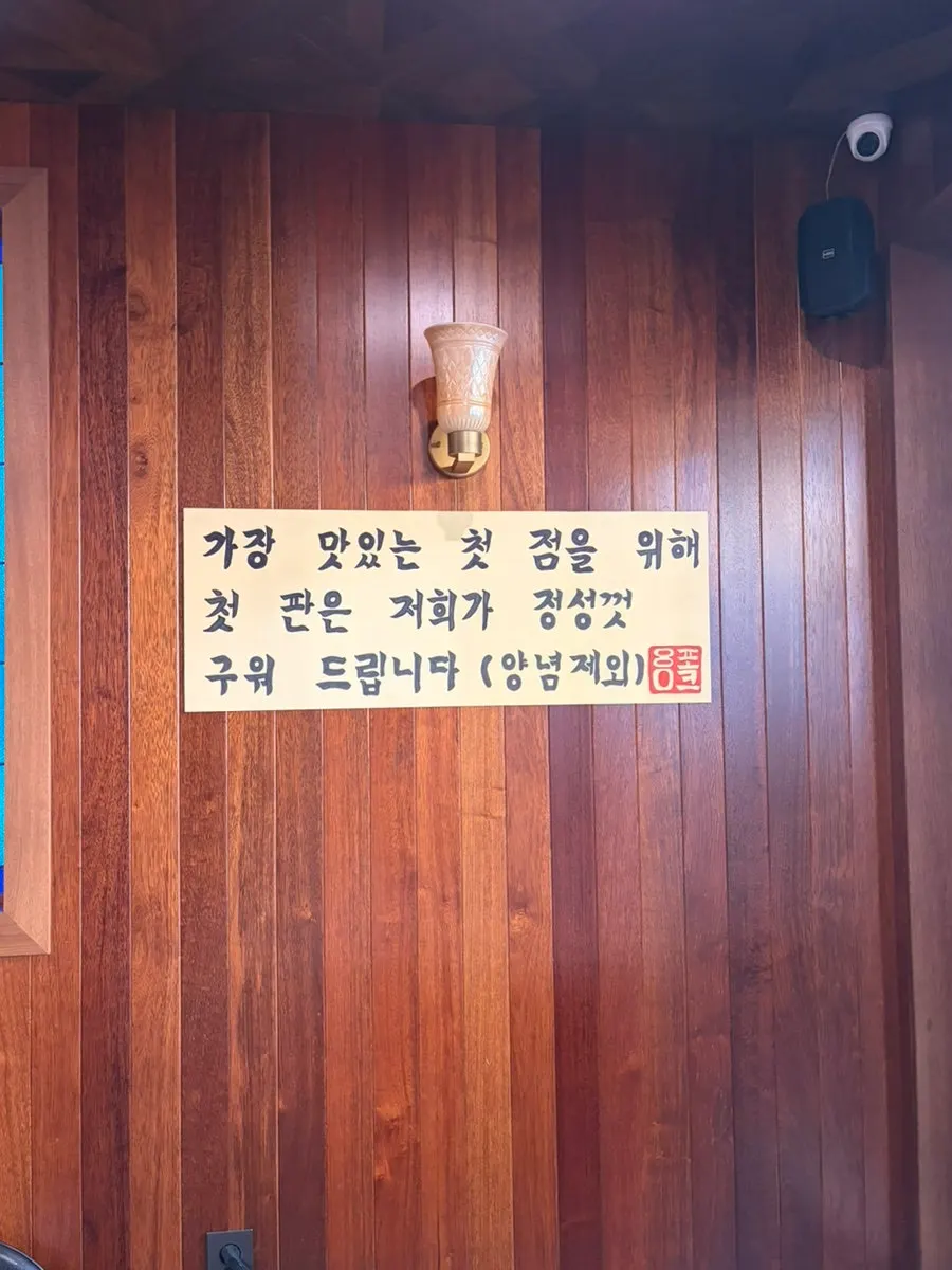 Wall sign explaining that staff grill the first batch