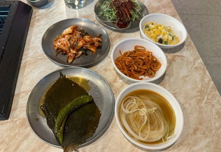 Table spread of various banchan at Pork80