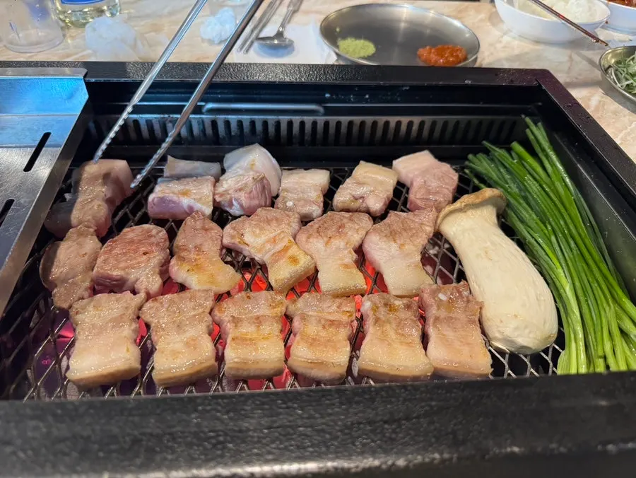 Staff grilling black pork with scallions