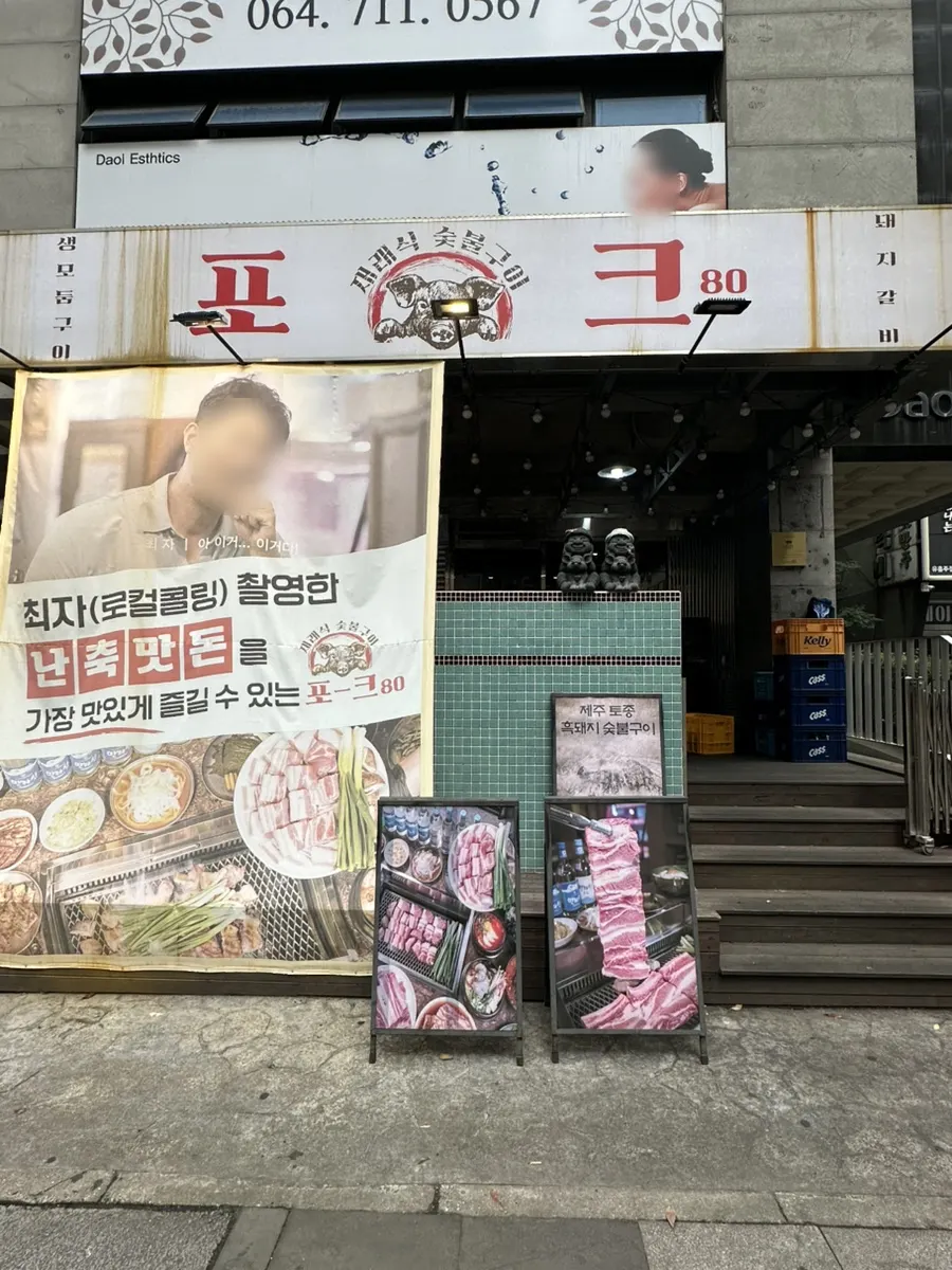 Entrance of Pork80 Jeju Airport Branch with a Choi Ja Road standee