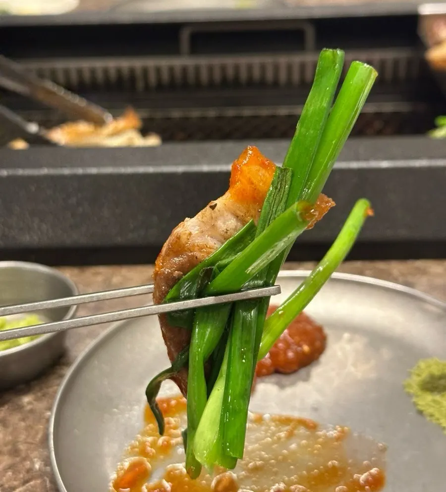 Black pork wrapped in a grilled scallion