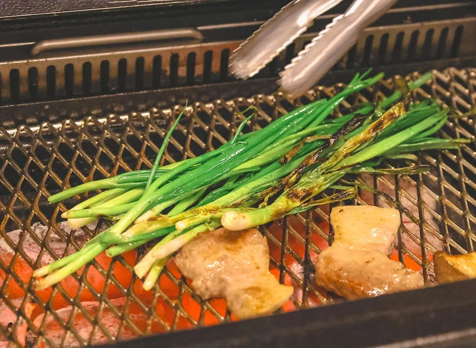 Grilled scallions and mushrooms cooked alongside the meat