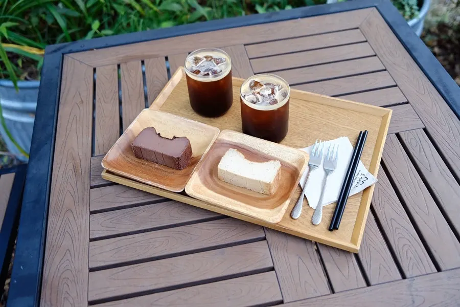 Iced Americano and Basque cheesecake on a wooden tray