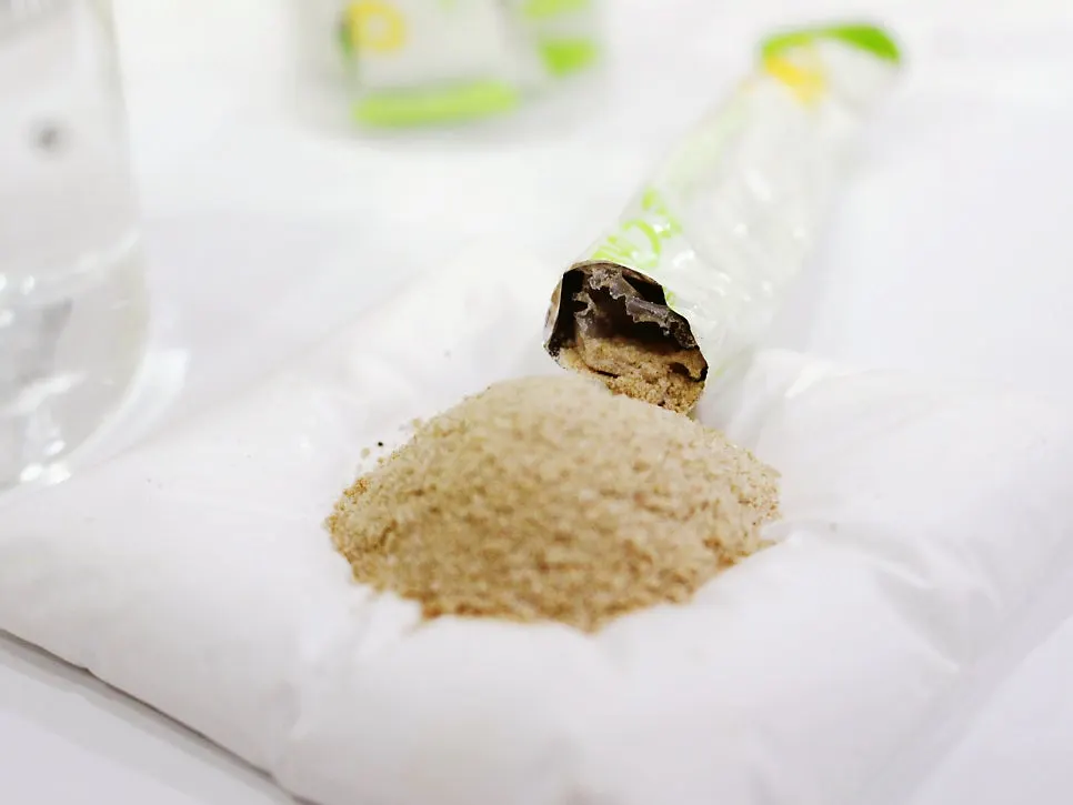 A cup and stick pack placed together showing how Pine Jafi is taken