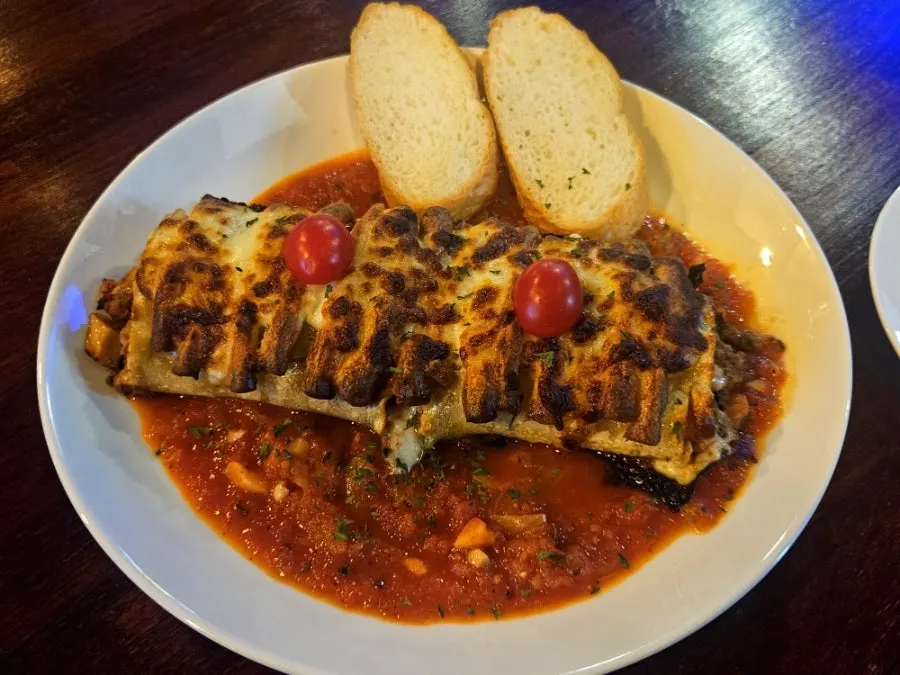A plate of beef roll lasagna with melted cheese