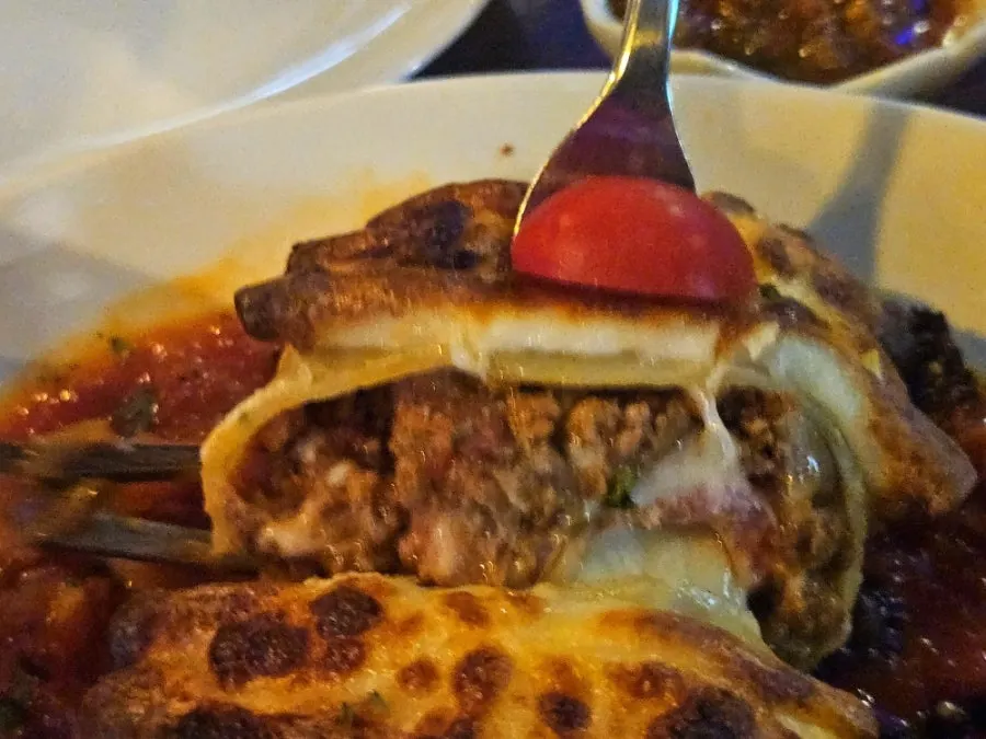 Beef roll lasagna topped with basil pesto