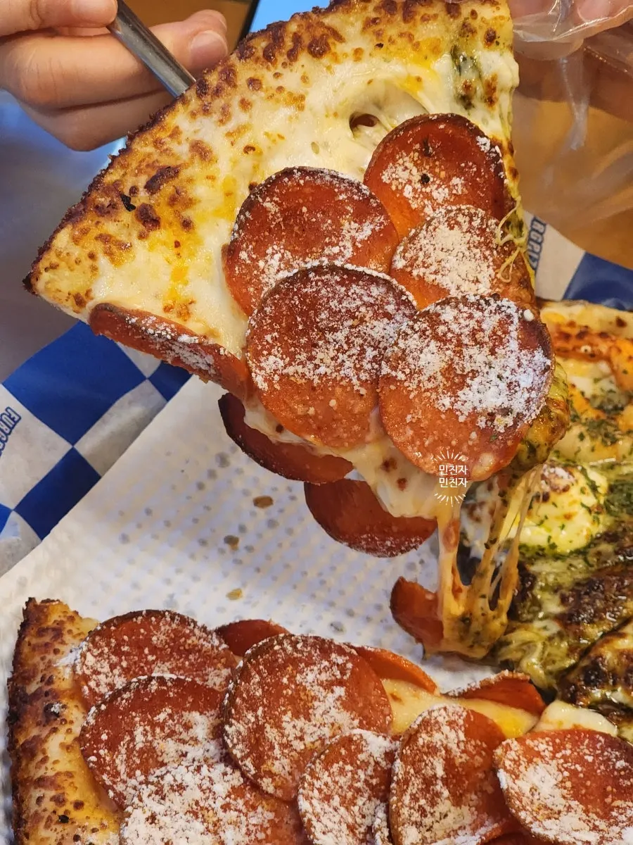 A slice of hurricane double pepperoni pizza with stretching cheese