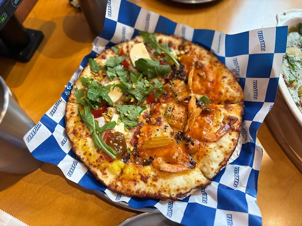A slice of Pug Pizza House pizza loaded with toppings