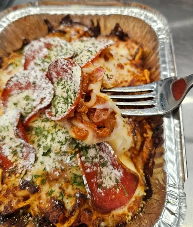 Forkful of oven spaghetti loaded with ground meat