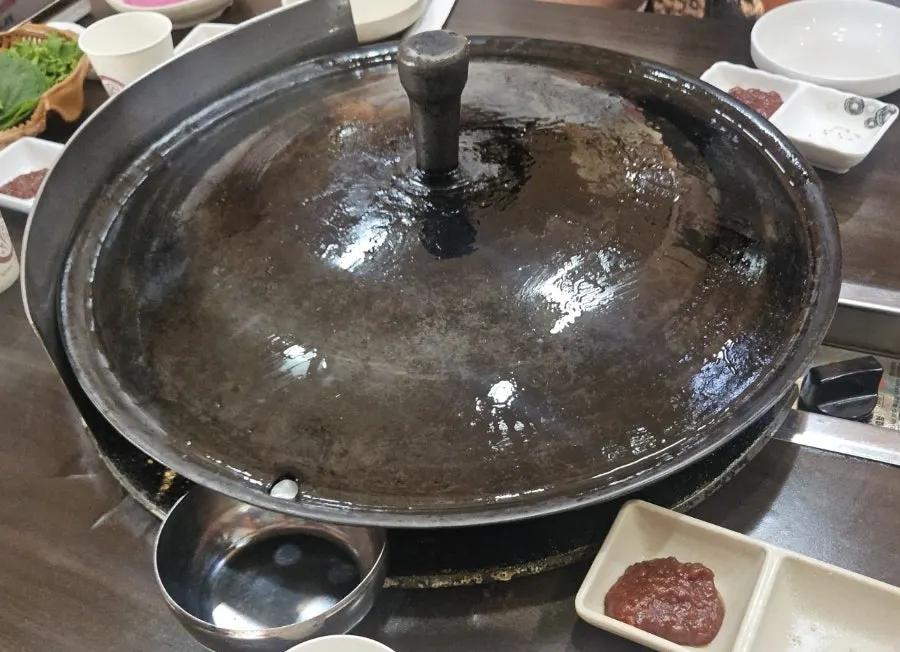 Susunan meja dasar dengan tutup kuali besi terpasang
