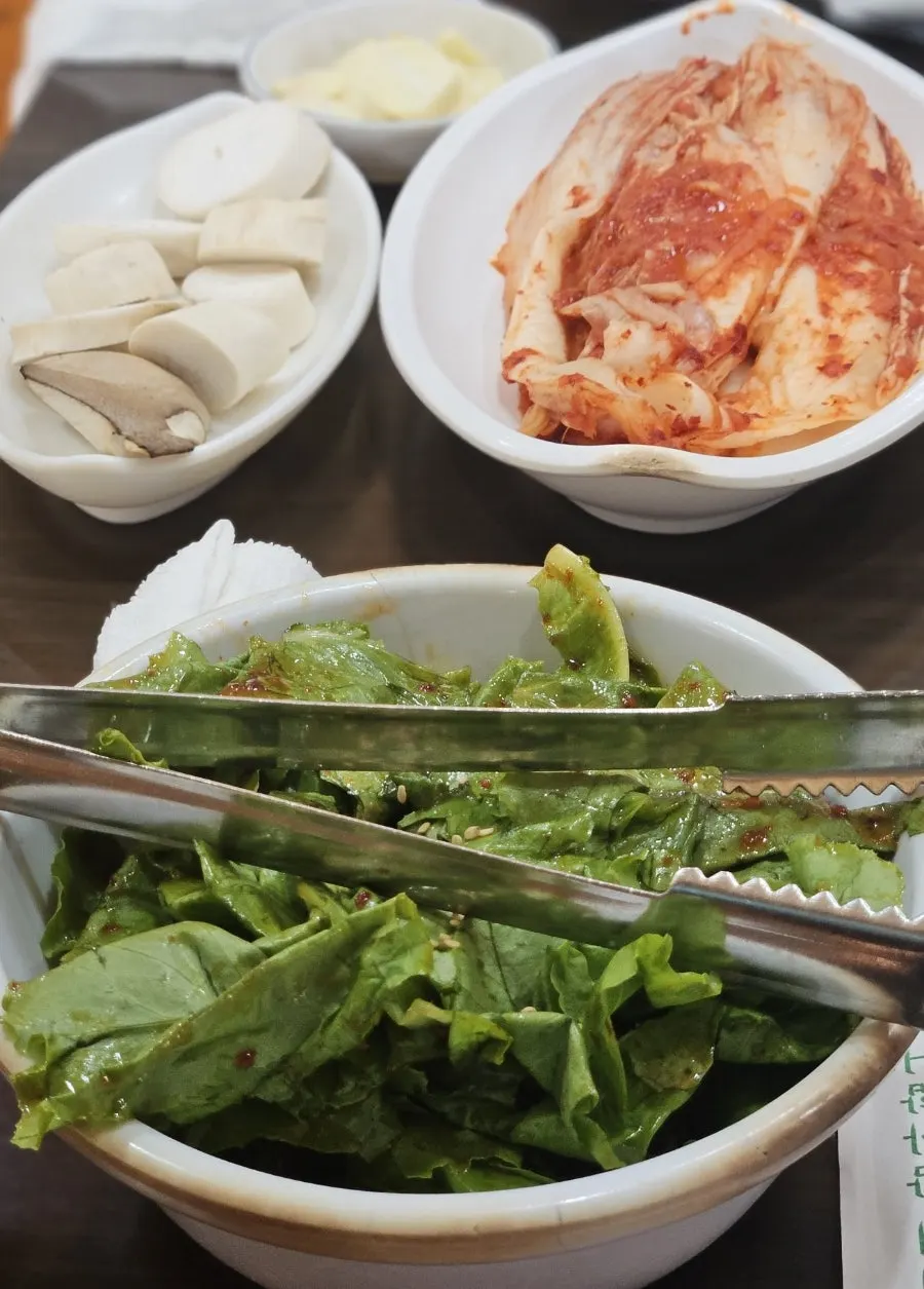 Lauk pendamping berupa jamur, kimchi, dan sayuran pembungkus