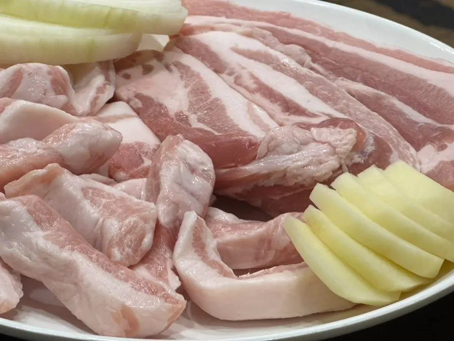 Two servings of raw pork jowl set on the table