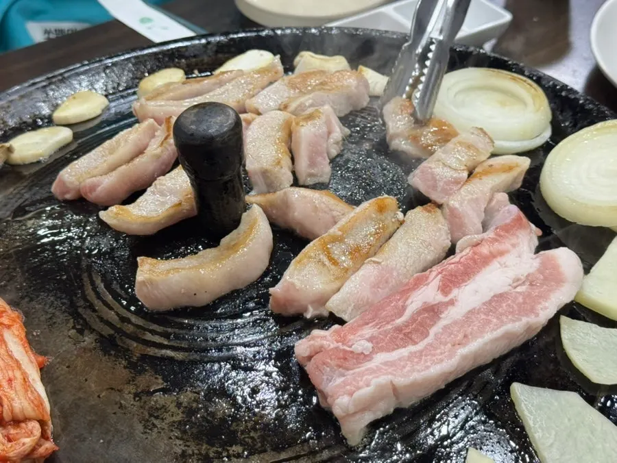 Pork belly starting to cook on the cauldron lid