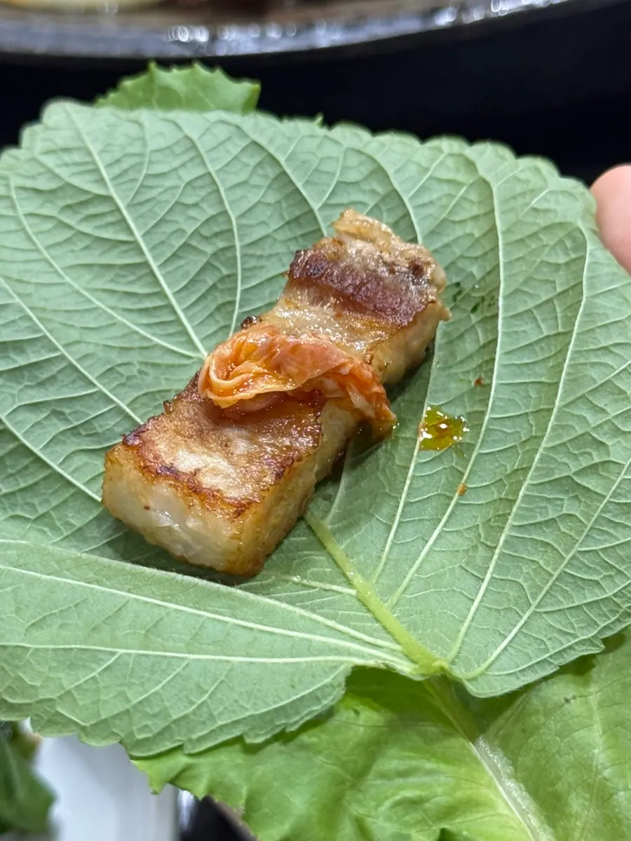 Meat and grilled kimchi wrapped in lettuce and perilla leaves