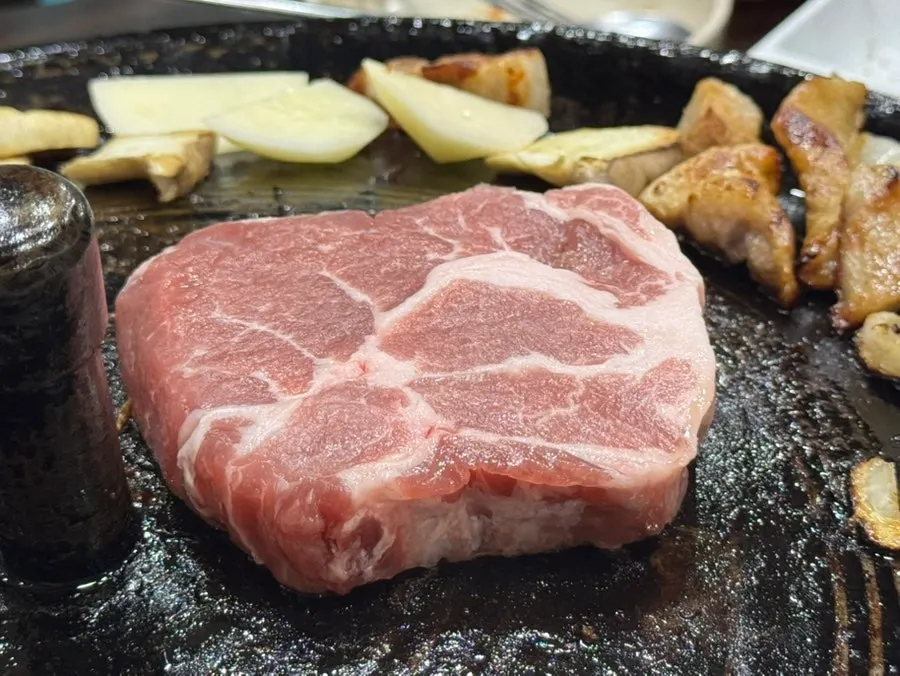 Meat and grilled kimchi on the cauldron lid