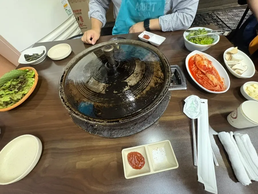Large cauldron-lid grill set up on a table