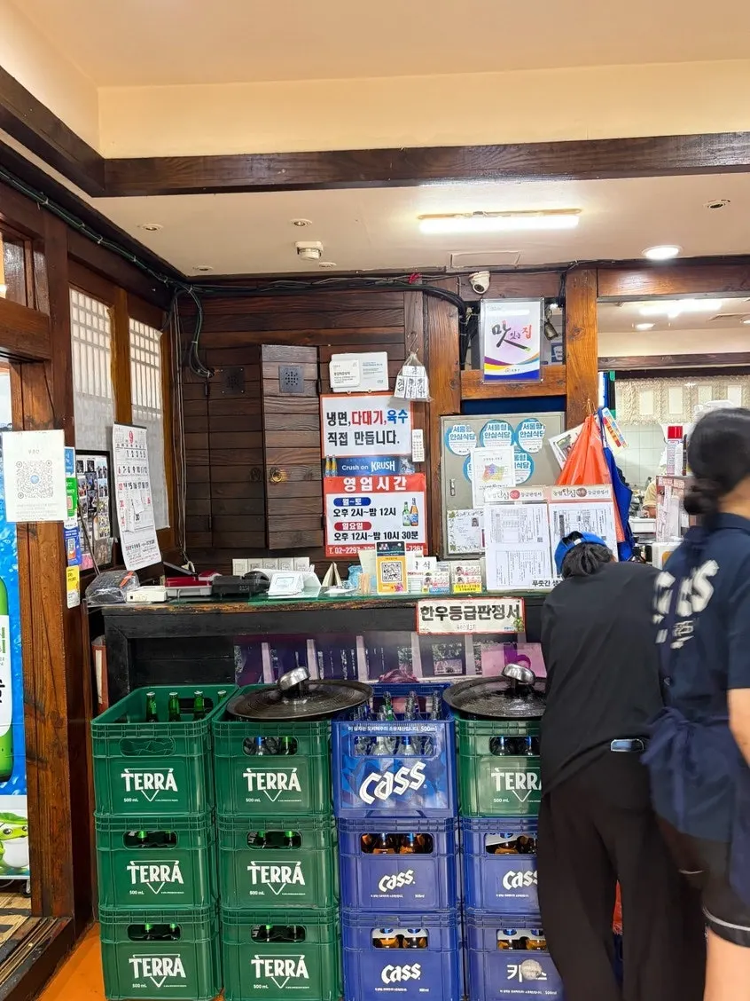 Cashier with sign noting homemade naengmyeon sauce