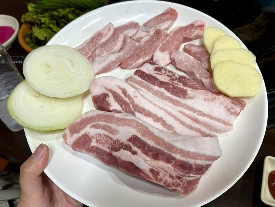 A plate of thickly sliced fresh pork belly and pork jowl