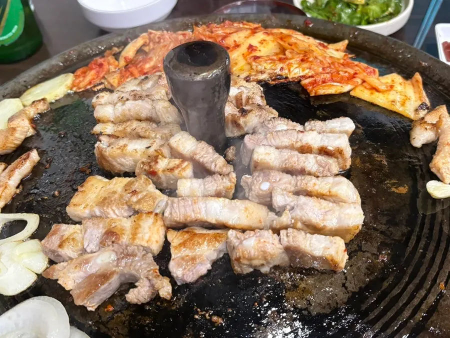 Thick pork belly turning golden brown on the grill