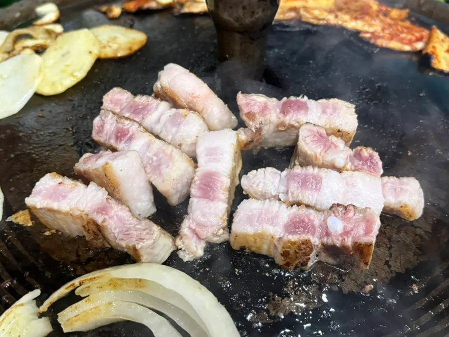 Table spread showing 4 servings of pork belly eaten by two people