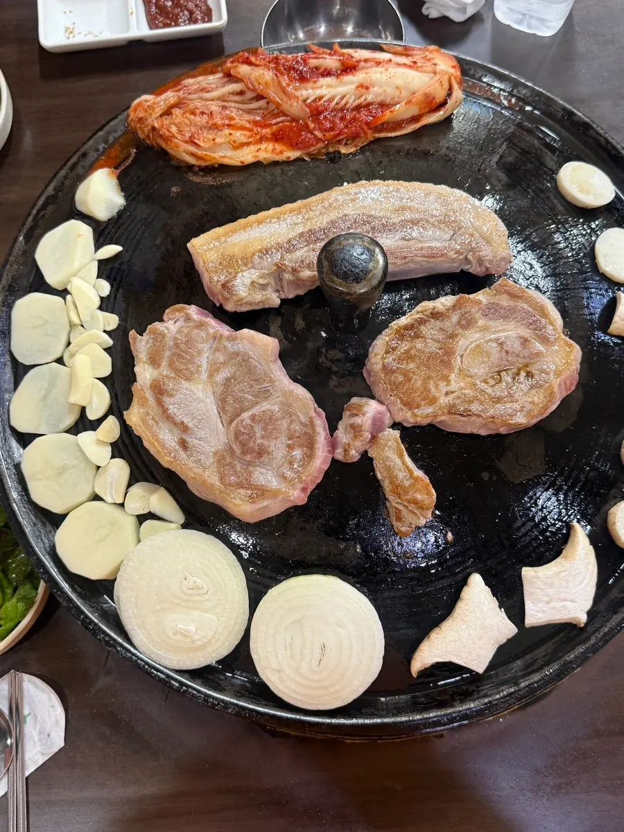 Golden-brown grilled pork belly and pork neck on the cauldron lid