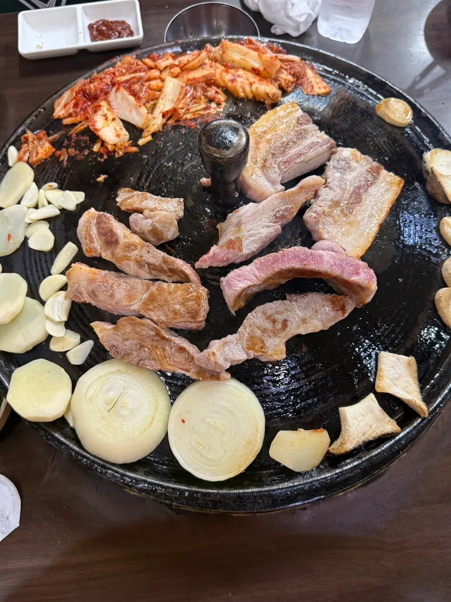 Meat cut by staff, served with kimchi, garlic, and potato