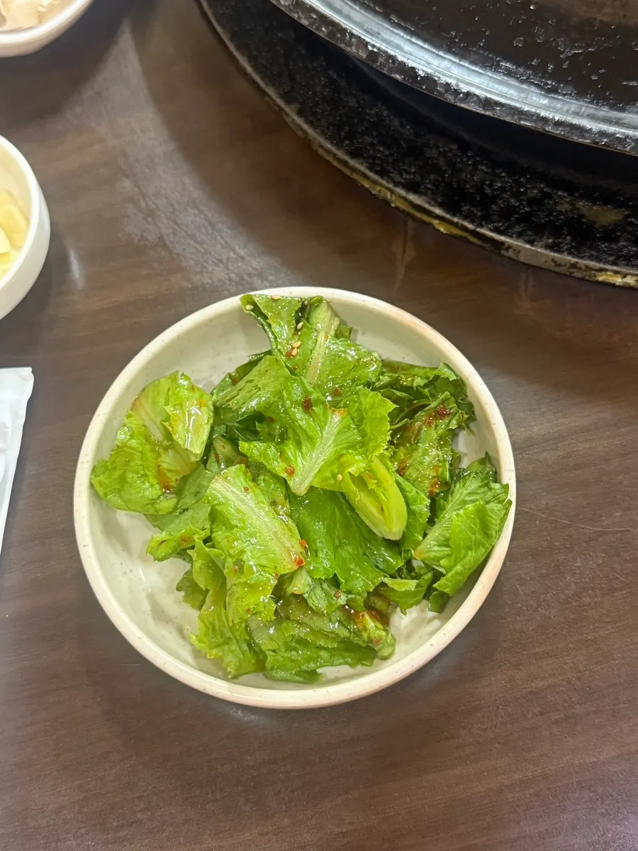 Grilled pork belly placed on a lettuce leaf side dish