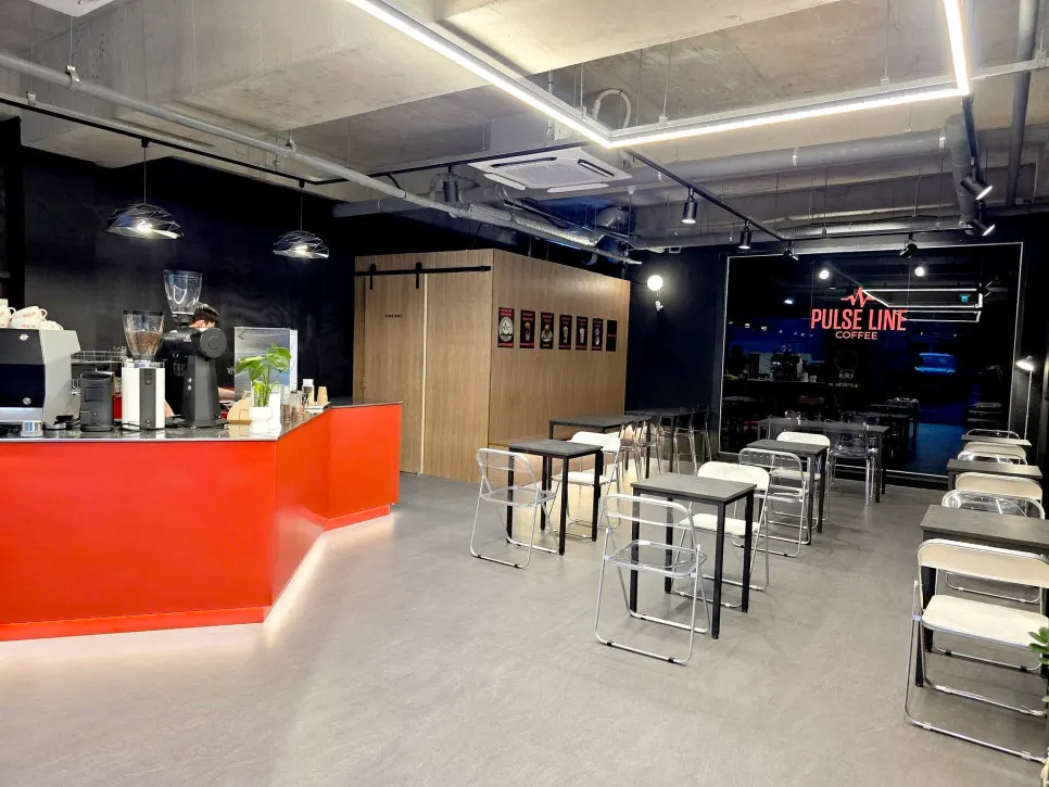 Interior of Pulse Line Coffee with floor-to-ceiling windows and two-seat tables