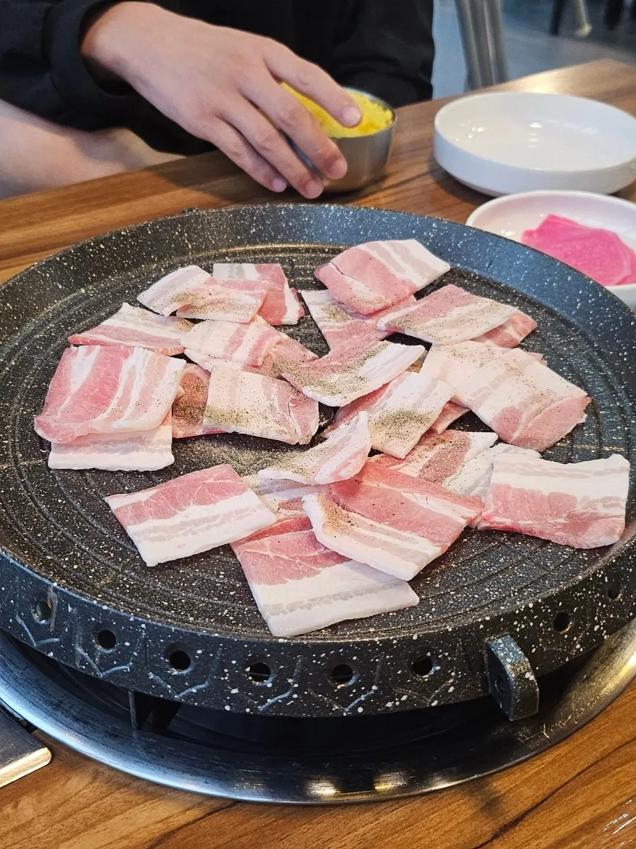 Shaved pork belly placed on the hot plate first