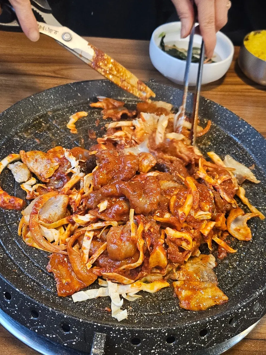 Staff member cooking octopus on the hot plate
