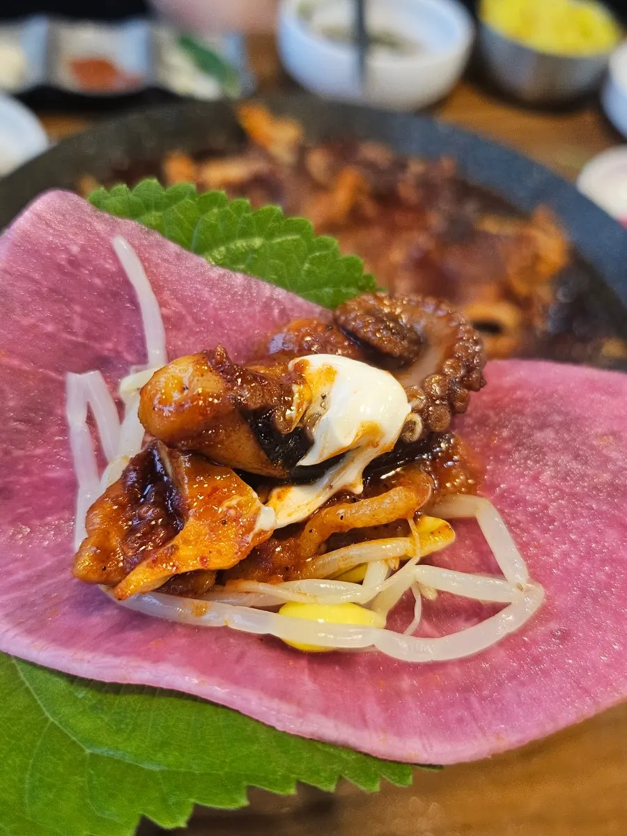 A piece of octopus placed on a perilla leaf