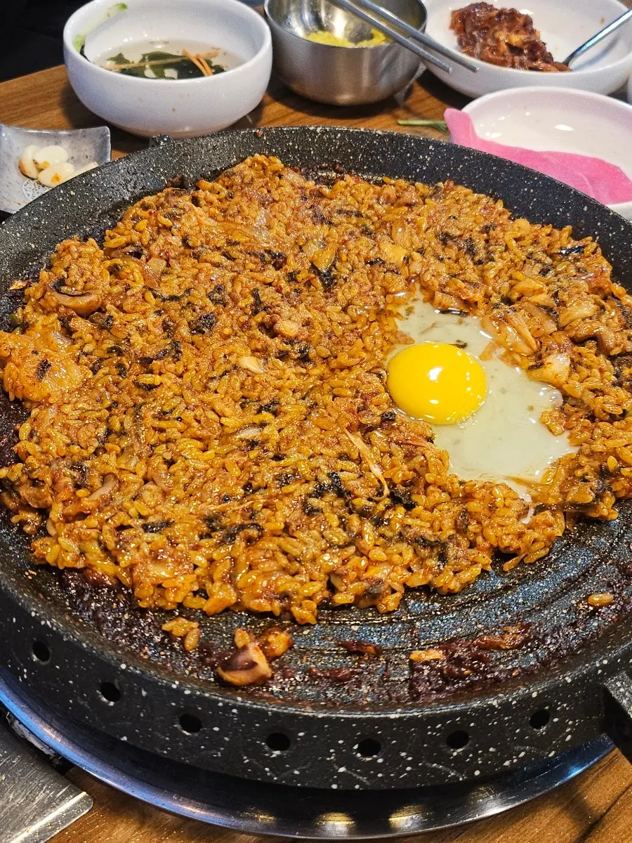 Octopus fried rice on the hot plate topped with a fried egg