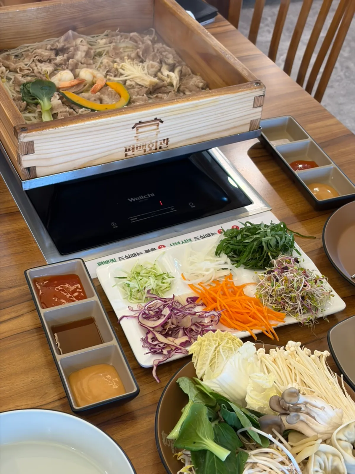 Mesa servida con pyeonbaekjjim y shabu-shabu en Pyeonbaek Hoegwan Cheoncheon Branch